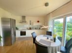 Moderne 3-Zimmer-Wohnung mit Einbauküche, 2-Tiefgaragenstellplätzen und 2 Bädern mit Blick ins Grüne - Einbauküche mit Essbereich